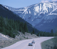 Two cars traveling on an Alaska highway.