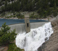 Photo of a dam with water flowing over the top.